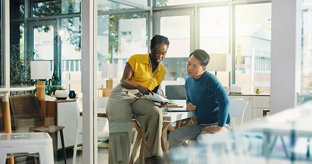 Two coworkers reviewing a document together at an office desk