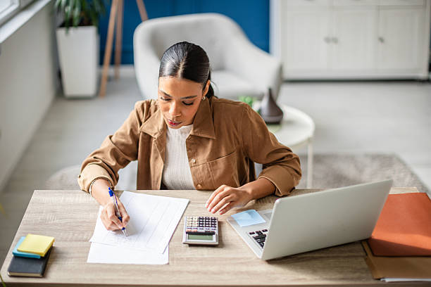 woman at desk with calculator and papers